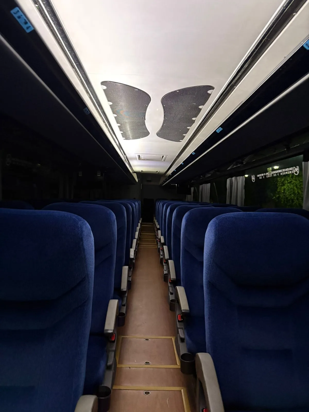 Interior del autobús Irizar i6 con asientos reclinables, pasillo central y pantallas de entretenimiento