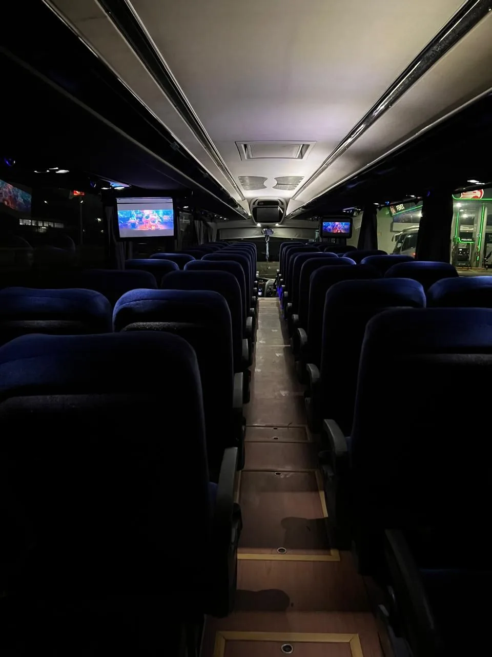 Interior del autobús Irizar i6 con filas de asientos y pantallas de entretenimiento