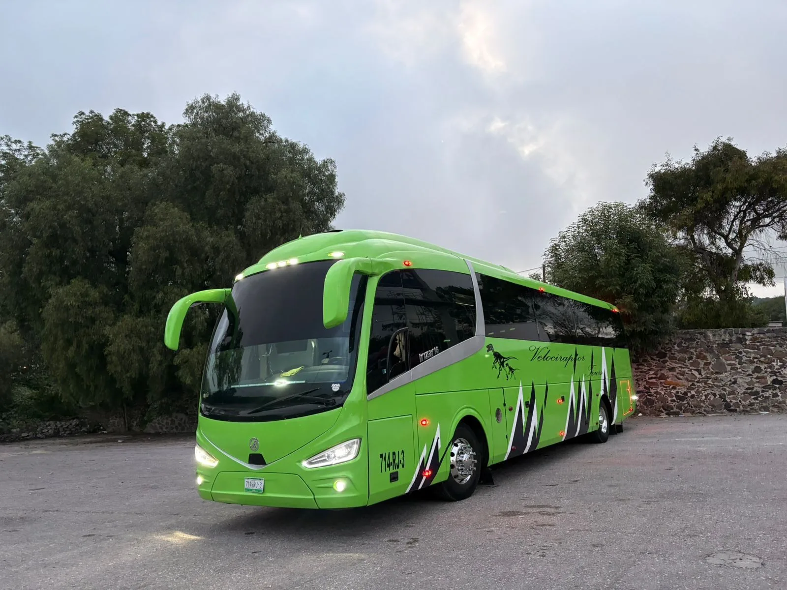 Autobús Irizar i6 verde estacionado frente a vegetación