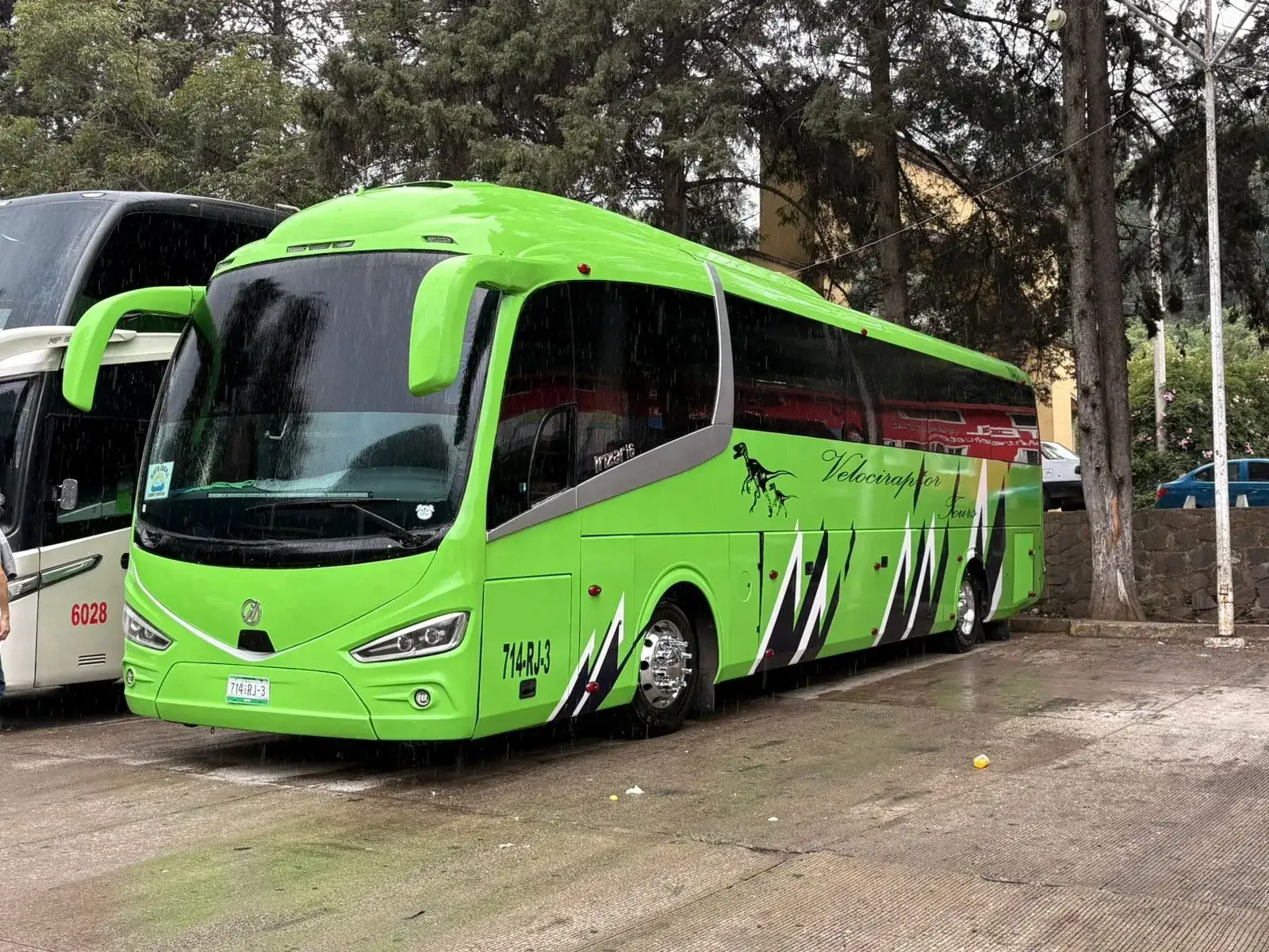 Vista exterior del autobús Irizar i6 verde estacionado junto a árboles